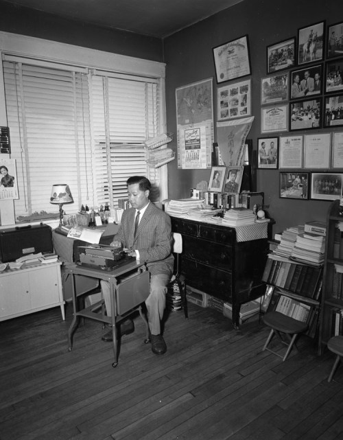 A man typing at a very small desk