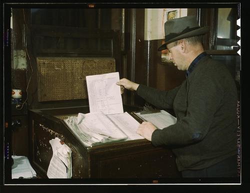 2179186358_92b1f1dfac_o Man checking over lists. He is wearing a great hat.