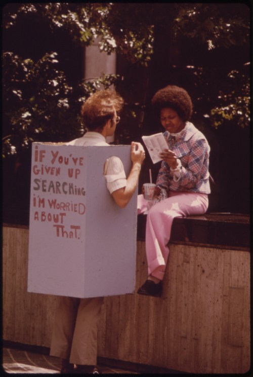 man wearing box speaks to woman