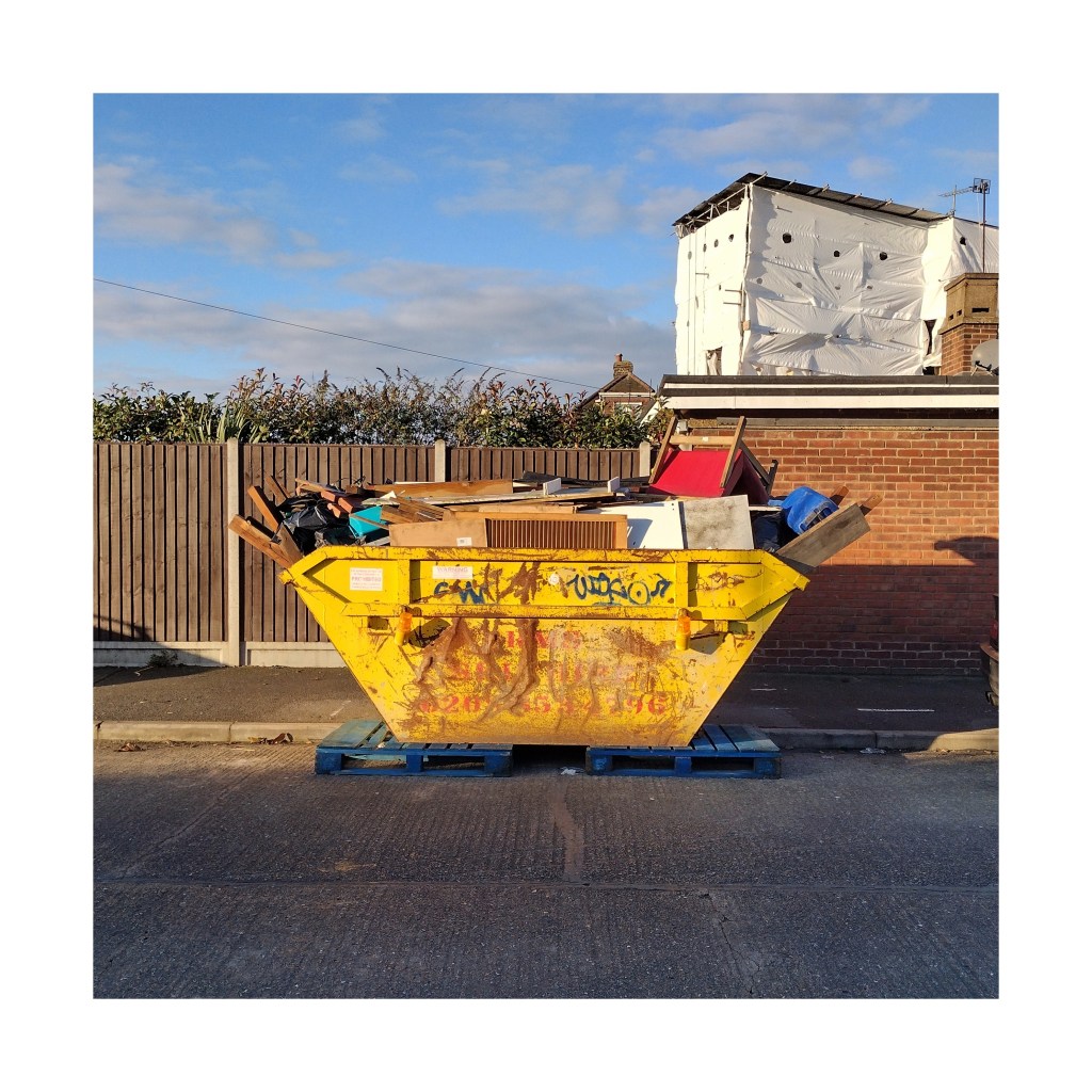 A full, yellow skip in the road