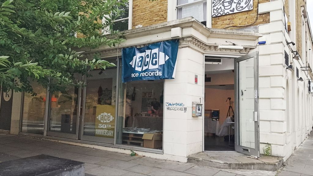 Exterior of shop with Ace Records banner hung from top, with Ace 50th Anniversary sign in the window.