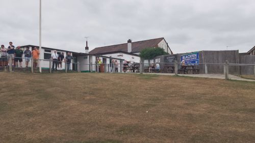 Top of the hill, clubhouse and tea bar at the peak, people watching football going on down below
