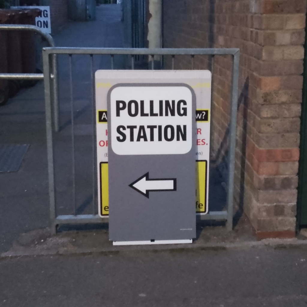 Polling Station sign in the street, a path behind it