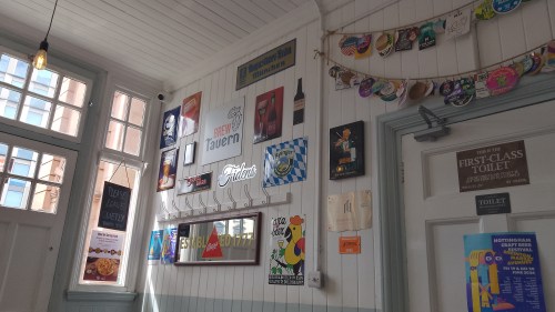 Interior of Brew Tavern, Nottingham. White wooden-slatted walls adorned with a Bass mirror and various old metal beer adverts
