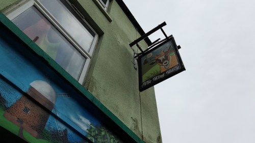 The exterior of the King Billy pub. A sign hangs off the wall with a picture of a goat.